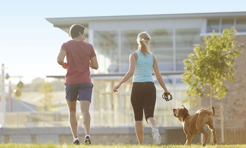 Image of couple running with a dog